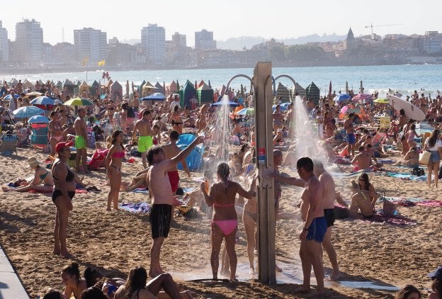 Las duchas aliviaron el calor de muchas de las personas que acudieron a pasar el día en la playa de San Lorenzo. 