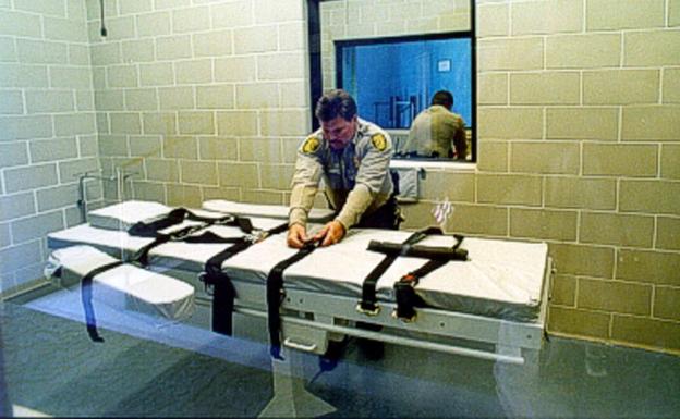Un policía preparando la camilla en la que se ajusticiará a un condenado. 