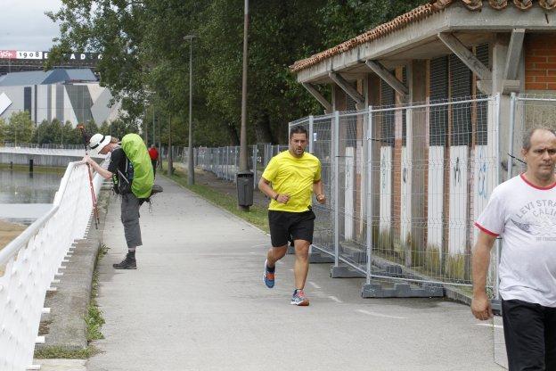 Una hombre corre por el 'Kilometrín', junto a las vallas que mantienen la pista cerrada por las obras de remodelación. 