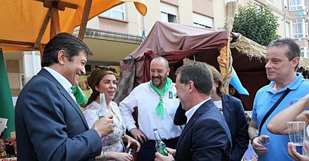 Ana Emilia Ordóñez y Ricardo del Río, ofreciendo un botellín de sidra al presidente y los consejeros a cambio de que señalicen el museo naveto. 