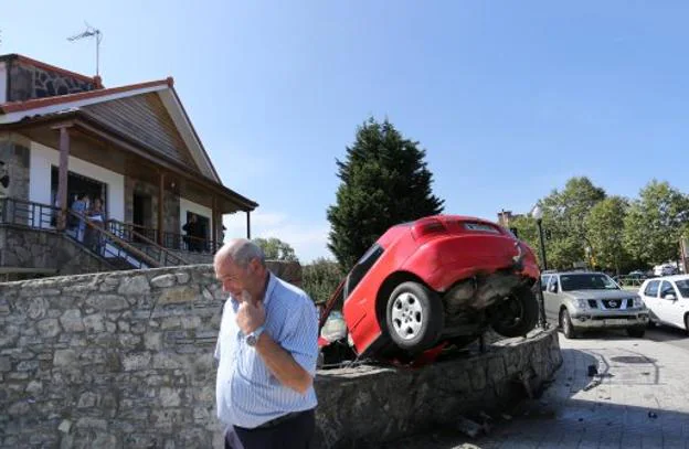 El propietario de la vivienda, delante del coche que invadió su propiedad. 