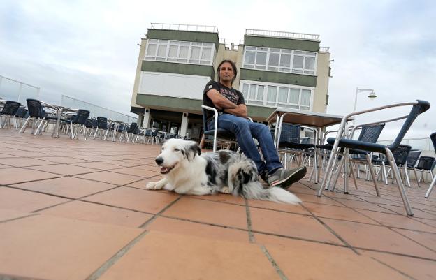 Carlos Quiroga, ayer, en la terraza de su café junto a su perra border collie 'Linda'. 