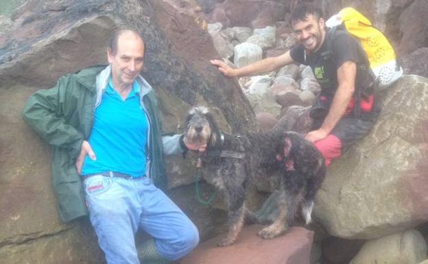 Antonio Cuesta, con ‘Ron’ y su rescatador, Carlos Rodríguez, en el acantilado de Selorio.