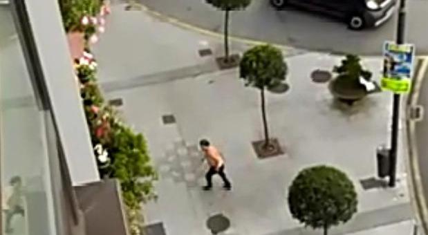 Secuencia. Captura de imágenes de un vídeo grabado por los vecinos en el que se ve al individuo cortar el tráfico, lanzar una bicicleta y arremeter contra un bar. ::VÍDEO ENVIADO POR ALBERTO VIOR
