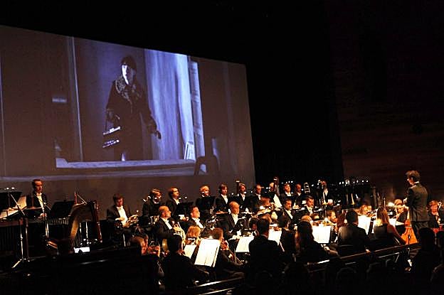 Un momento de la proyección, con la OSPA poniendo la música desde el foso. 