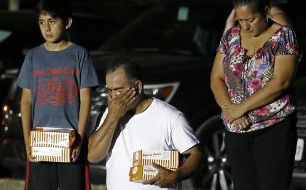 Un hombre de rodillas llora durante una vigilia en honor a los fallecidos. 