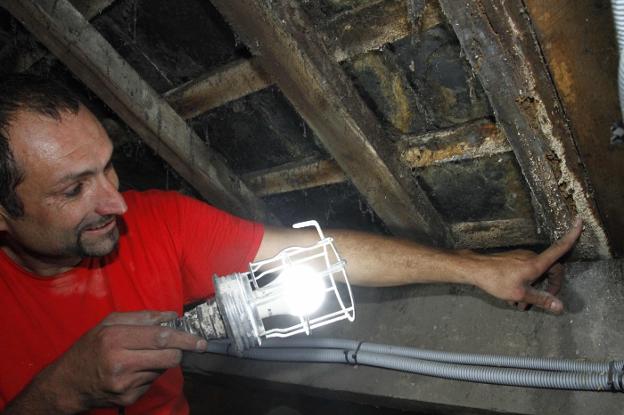 Uno de los empleados que trabaja en la limpieza de la madera muestra los surcos creados por las termitas en el tejado. 