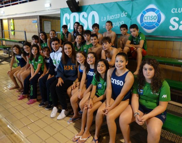 Los integrantes de los equipos prebenjamín y benjamín, con los nadadores de la formación absoluta César Castro y Fátima Gallardo, en la piscina del Santa Olaya. 