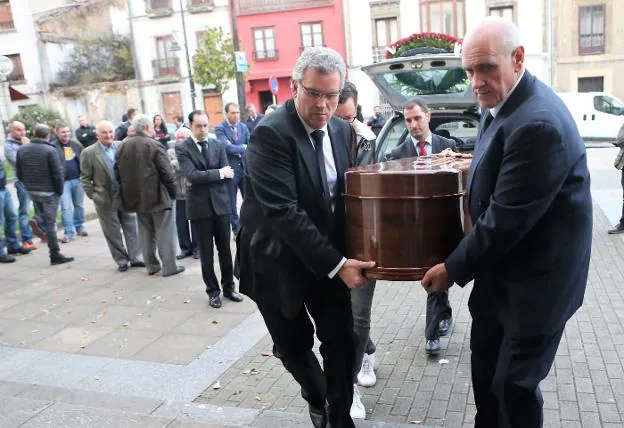 Los hijos de 'El Guaxu', Daniel, Xuacu Xosé y Ramón Vigil llevan su féretro dentro de la iglesia. 