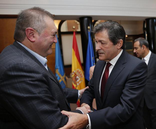 El coordinador de IU, Ramón Argüelles, y el presidente, Javier Fernández, se saludan en una reunión presupuestaria. 