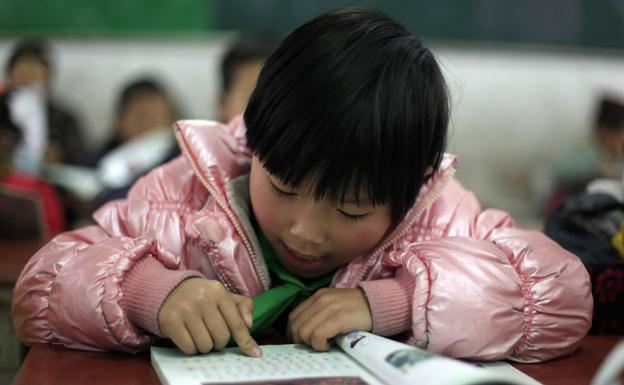 Niños chinos asisten a clase en una escuela. 