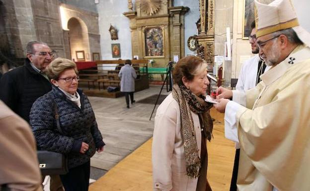 La sobrina nieta de José María Fernández Carmen Tosal besa las reliquias bajo la mirada de Jesús Sanz Montes. 