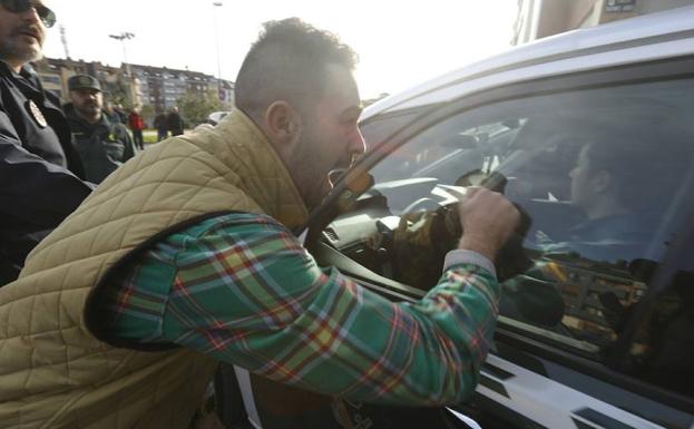 Brayan Tuero, en el interior del coche policial, increpado a la salida de los juzgados.