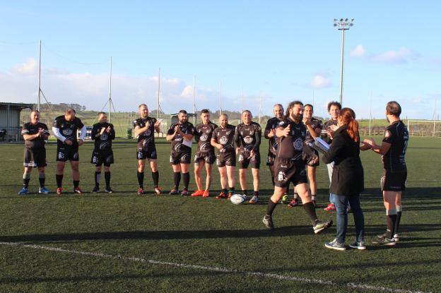 Los jugadores del Candás Rugby reciben sus títulos de 'lords' de la mano de Marta Biadiou. 