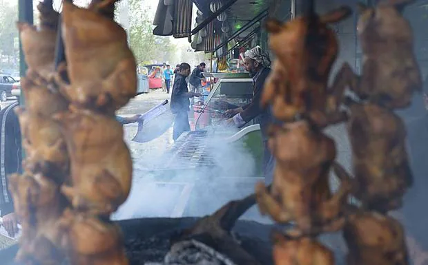Un vendedor de carretera afgano prepara kebabs de carne. 