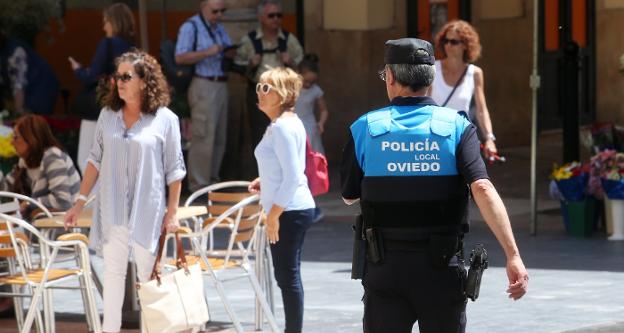 Un agente de la Policía Local vigilando una plaza del Oviedo Antiguo. 