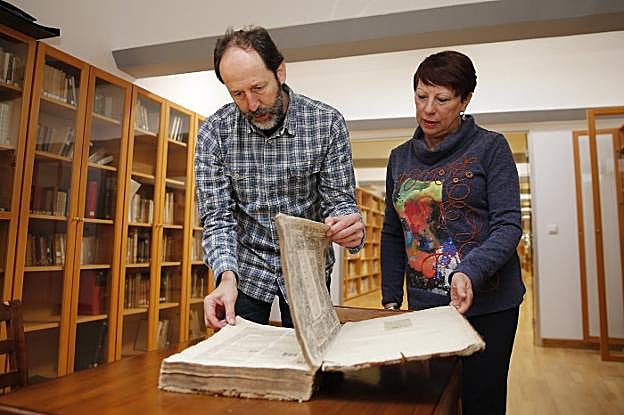 Entre libros. Martínez y Pacheco hojean un ejemplar de 1550, que aparece tumbado en la balda superior en la imagen de la izquierda. Sobre estas líneas, una obra de 1676. 