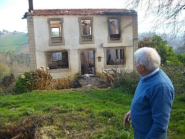 Manuel Méndez, vecino de Riobón, con su casa calcinada. 
