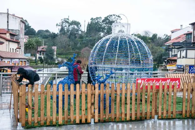 Los operarios terminan de instalar la bola gigante en Llanes. 