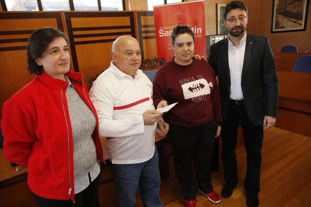 Los representantes de Cruz Roja, Sandra García y Manuel León, recogen la recaudación que les entregó Lantero. 