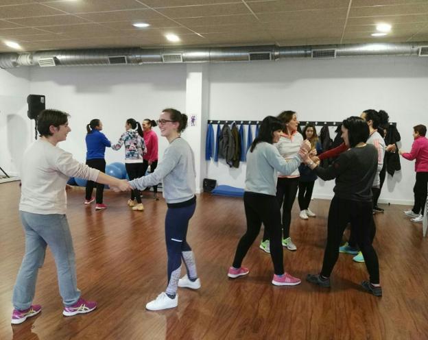 Las participantes del taller practican técnicas para zafarse de un posible agresor. 