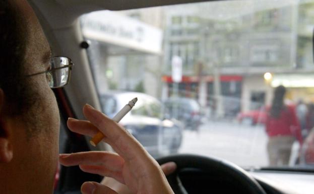 Un conductor fumando. 