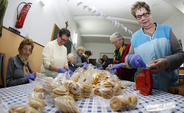 María Rosa Casaprima, a la derecha, cierra los paquetes de rosquillas, junto a otras voluntarias. 
