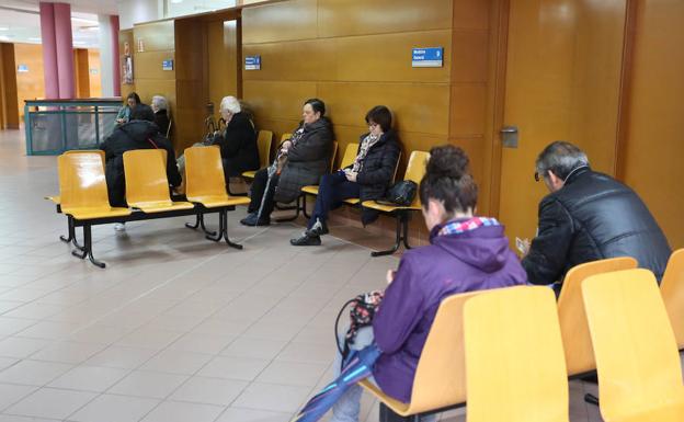 Pacientes en la sala de espera de la consulta médica del centro de salud de Laviada durante la epidemia de gripe