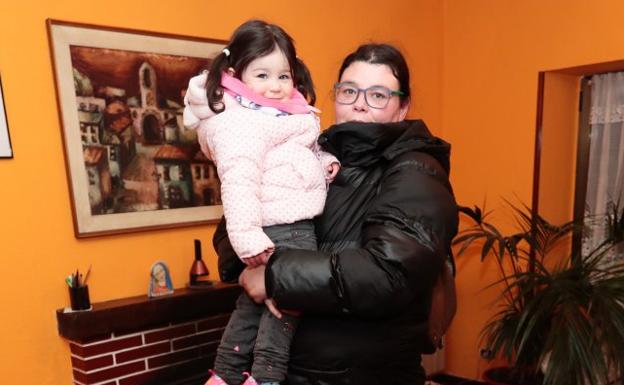 Jessica Rodriguez, con su hija Indira en brazos, en el salón del centro de ayuda de Roces. 