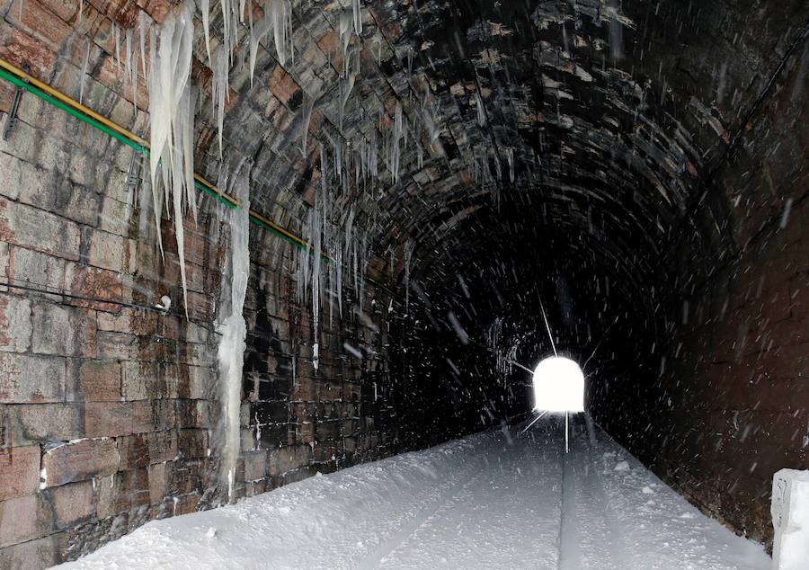 La nieve caída en las últimas jornadas ha dejado estas espectaculares imágenes de la línea ferroviaria en Busdongo, que une León y Asturias, que se encuentra suspendida