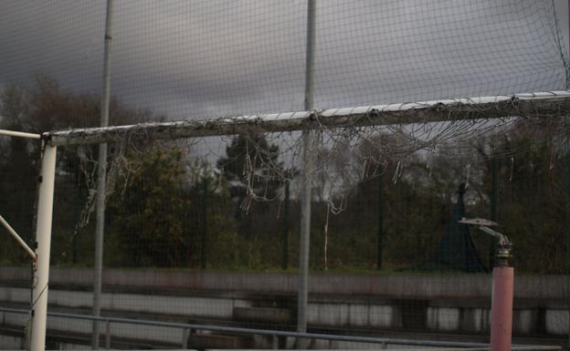 Las redes de las porterías se han deteriorado y en el césped sintético afloran las hierbas. 