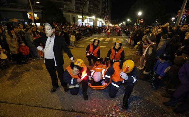 Antiguos voluntarios de Protección Civil con caretas del edil Esteban Aparicio, durante el desfile oficial. 