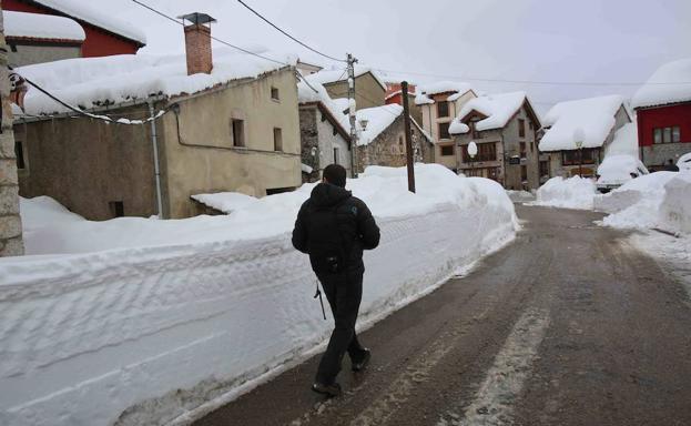 Imagen principal - Arriba, la nieve en Sotres. Abajo a la izquierda, un niño en trineo; a la derecha, un hombre practicando snowboarding.