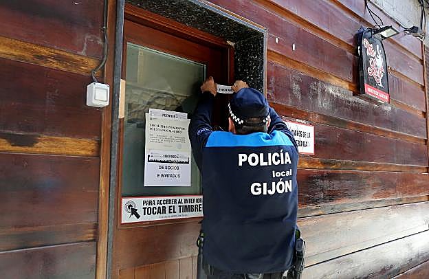 Un agente precinta un pub en la calle Almacenes. 