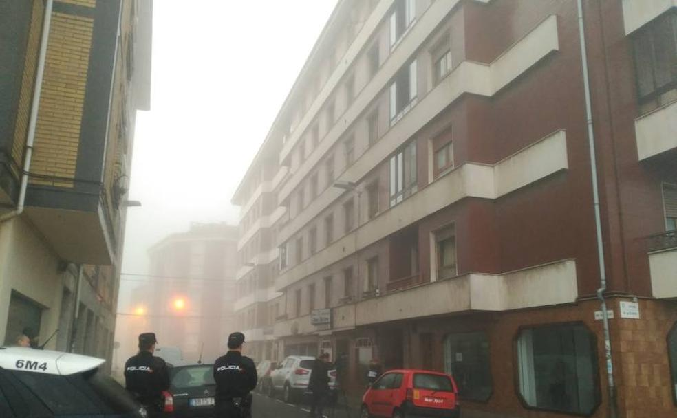 Dos agentes de la Policía Nacional, ante el edificio donde se produjo el siniestro en El Berrón.