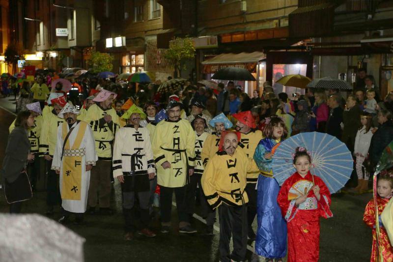Pequeños y mayores se enmascararon en la localidad llanisca para recorrer las calles a ritmo de carnaval, a pesar de la lluvia.