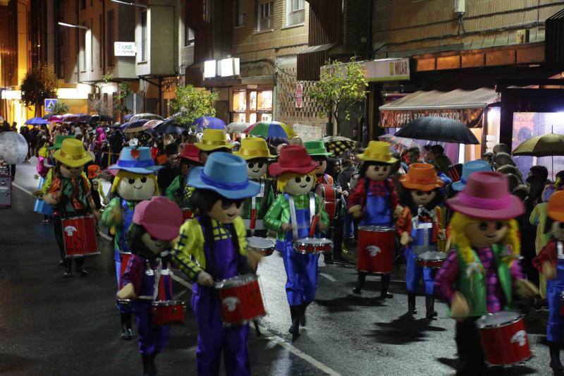 Pequeños y mayores se enmascararon en la localidad llanisca para recorrer las calles a ritmo de carnaval, a pesar de la lluvia.