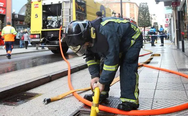 Un bombero coloca la manguera en un hidrante. 