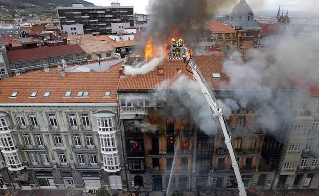 El incendio de Uría, 58 se desató el 7 de abril de 2016. En la imagen, dos bomberos sofocando las llamas desde lo alto. 