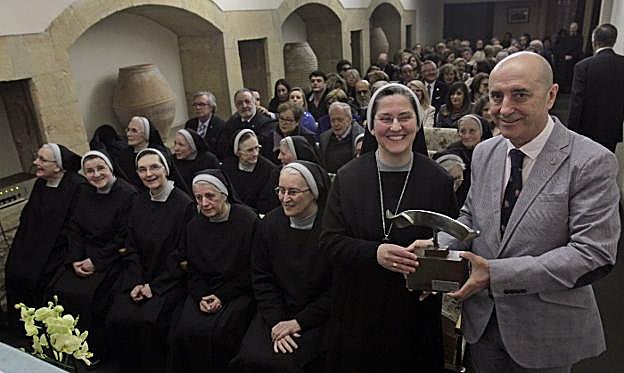 Manuel Menéndez, presidente rotario de Oviedo, entrega una escultura de Kiko Urrusti a la abadesa de Las Pelayas.
