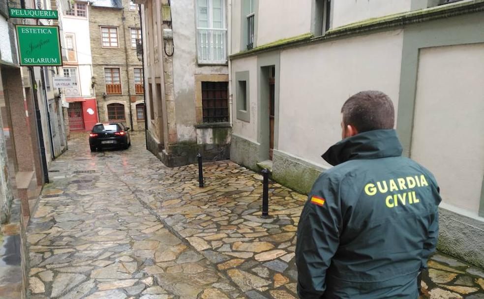 Efectivos de la Guardia Civil conducen a Javier Ledo a su vivienda, en el centro de Navia.