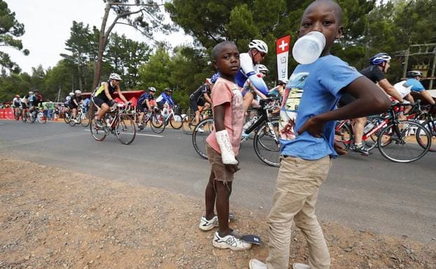 Dos niños observan el paso de una carrera ciclista en Ciudad del Cabo. 