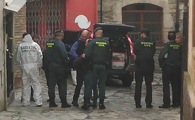 Javier Ledo, entre los agentes, a la salida del registro realizado en la tarde de ayer en su casa de la calle Hospital en Navia. 