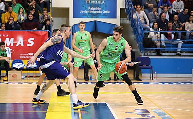 En una de sus primeras acciones con la camiseta del Unión Financiera Mike Carlson bota el balón ante la presencia de Javier Lucas.