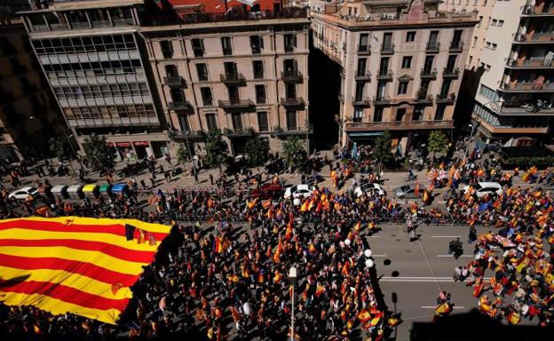 Miles de personas sostienen la bandera catalana.