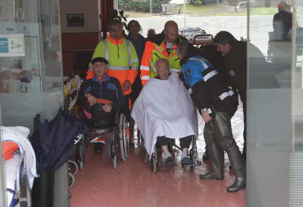 Dos ancianos a la espera de ocupar su turno en una ambulancia para ser trasladados de residencia. 
