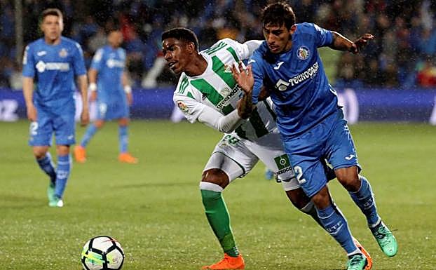 El defensa del Betis, Júnior, disputa el balón ante el jugador del Getafe, Damián Suárez.