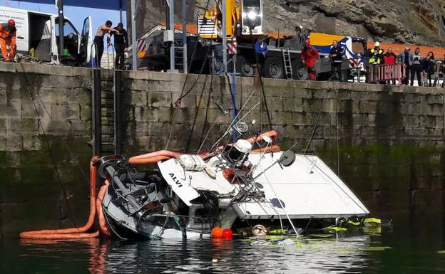 Trabajos de recuperación del 'Alvi', que volcó en el puerto de Lastres cuando descargaba. 