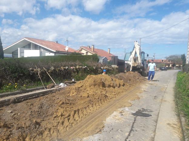 Una excavadora y dos operarios trabajan para levantar parte de la carretera de Rovigo, donde se instalarán las tuberías. 