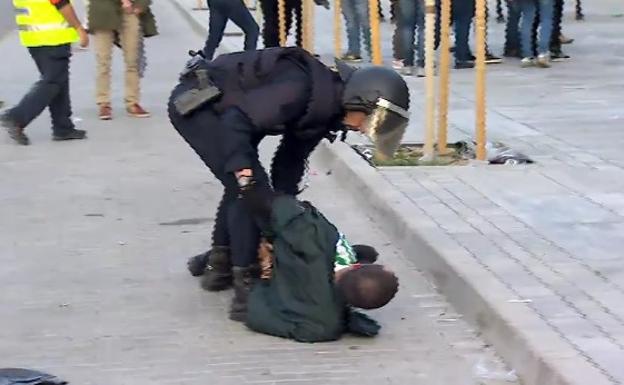 Un policía sujeta a uno de los autores de los incidentes.
